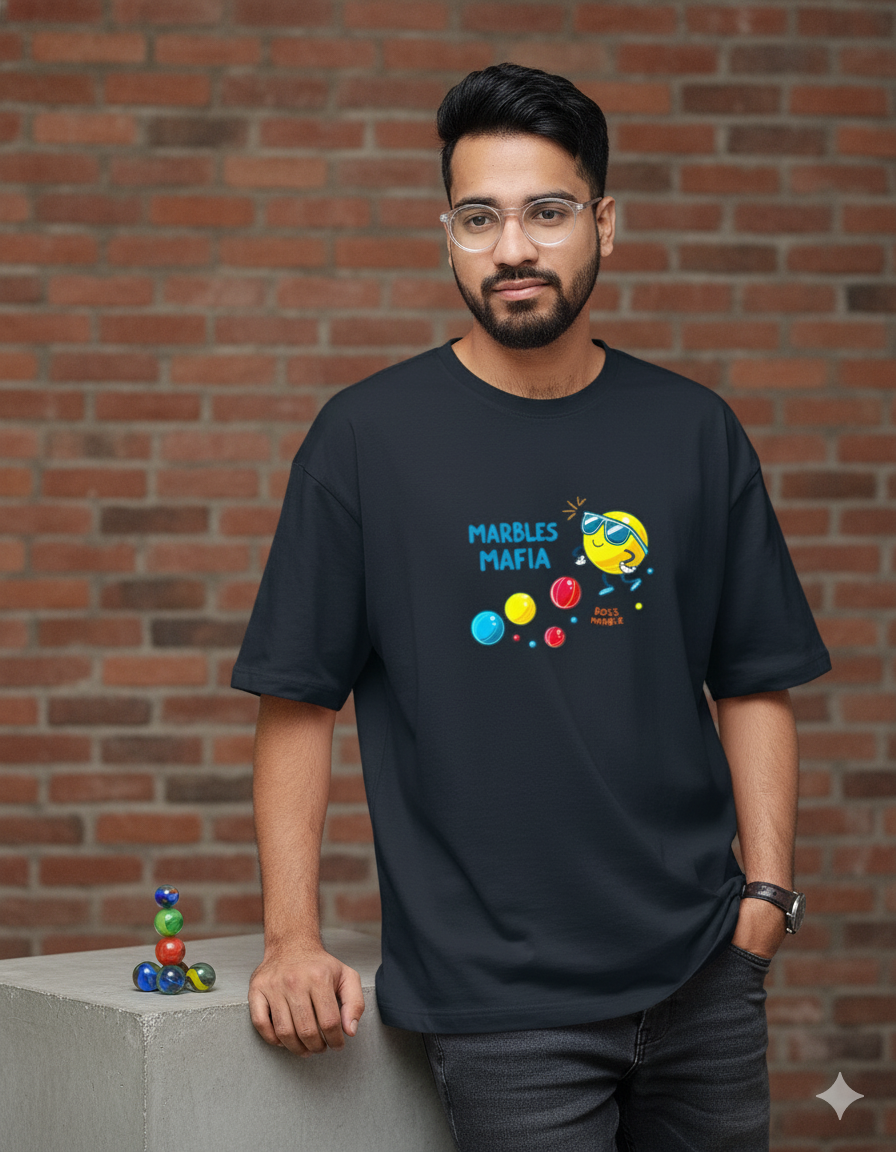 Person wearing a black t-shirt with colorful graphic design against a brick wall.